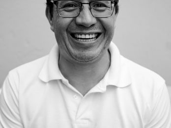 Photo of a Smiling man in a white t-shirt with glasses, in the park in black and white