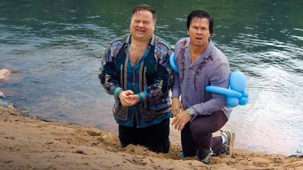 Two lead characters on a lake shore