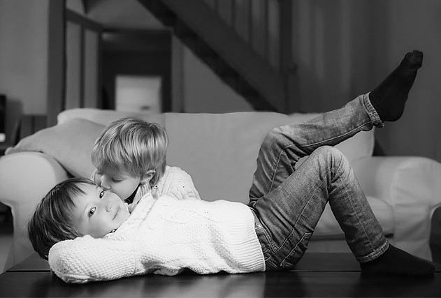 Black-and-white portrait of two siblings at home during a family photoshoot by Pennypics London Photography.
