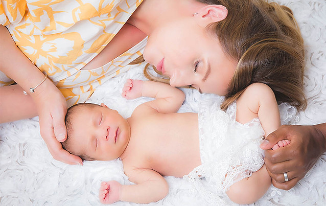 newborn photoshoot near me mom cuddling with a baby laying down