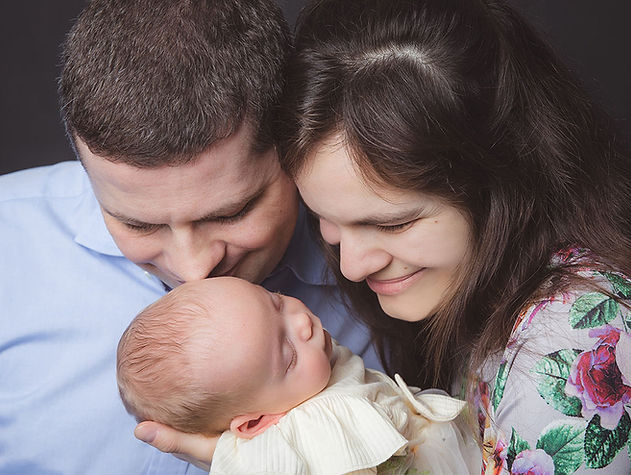 Parents looking tenderly at their sleeping newborn during a studio newborn photoshoot in South London.