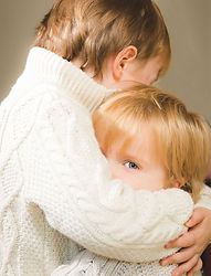 Two young siblings embracing during an autumn family portrait session.