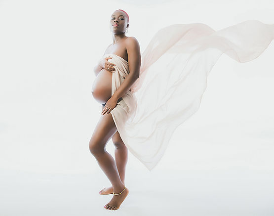 radiant-pregnant-woman-in-flowing-dress-posing-proudly-against-white-background-pennypics-studio-south-london
