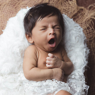Yawning newborn baby portrait in cozy setting, London studio photoshoot by Pennypics.