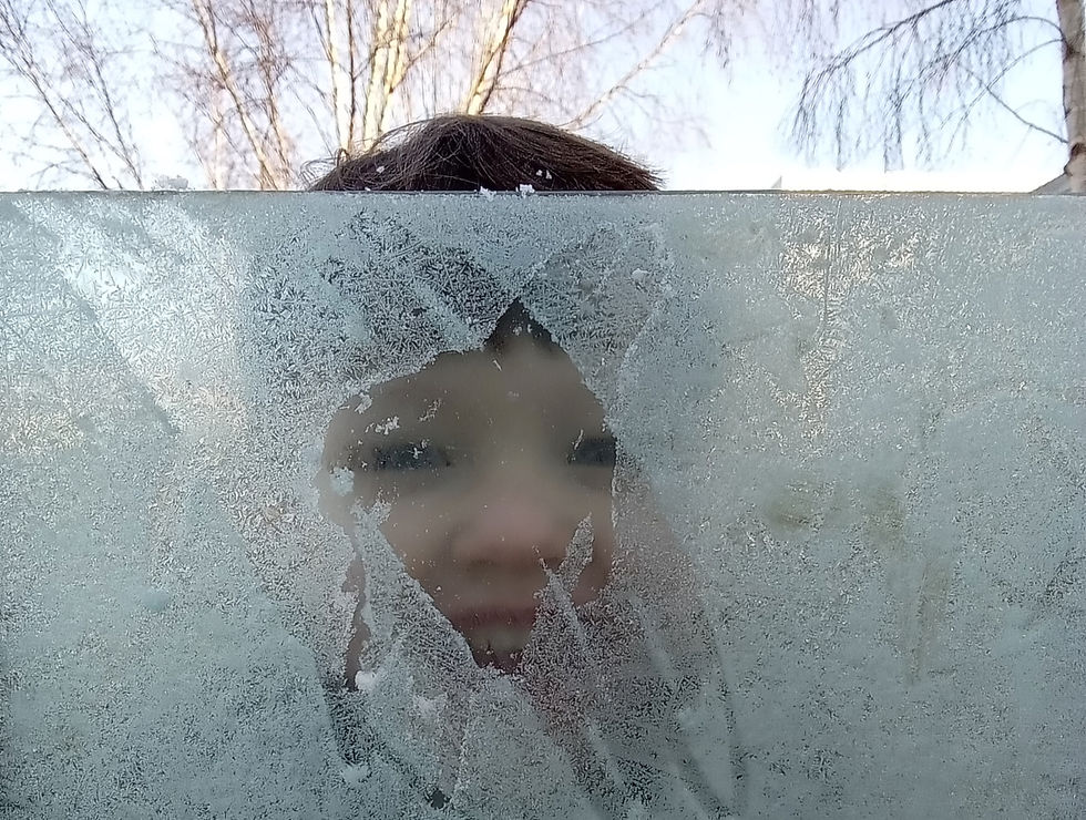 Teachers and students smile and show peace signs in a classroom with colorful posters on the walls, creating a joyful atmosphere.