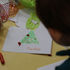 child draws a Christmas card