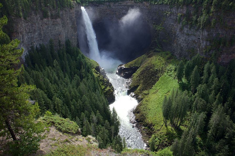 Waterfall surrounded by conifer forest in North West Canada