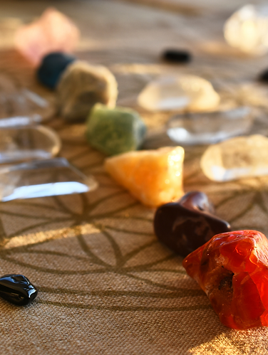 Pierres et cristaux représentant les chakras sur une fleur de vie