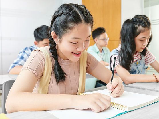smiling-asian-school-children-writing-textbooks-class (1)_edited.jpg