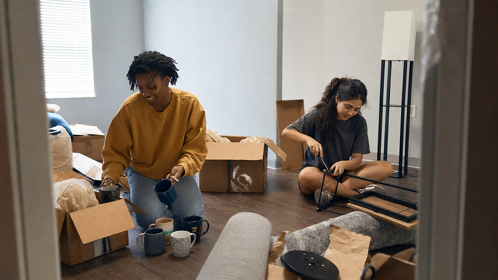 Two roommates unpacking coffee mugs and assembling furniture in their new Orlando apartment