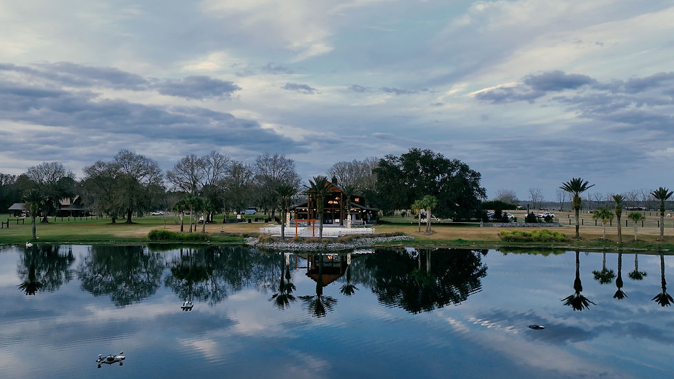 the barn at cottonwood ranch at twilight with an aerial drone photo from the lake looking toward the barn and trees