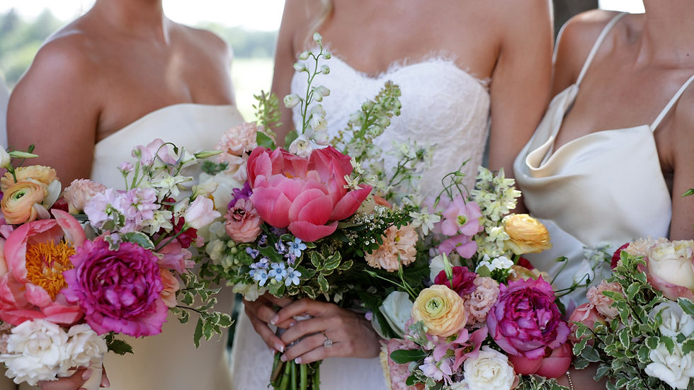 bride and bridesmaids in strapless dresses holding vibrant floral bouquets with a Spring palate full of pinks, yellows, oranges, whits and greens by Shea Hopely Floral & Event Design at TPC Sawgrass