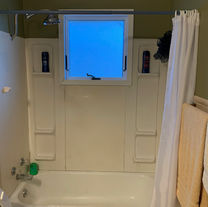 Old, outdated tub with plastic walls and shower curtain.