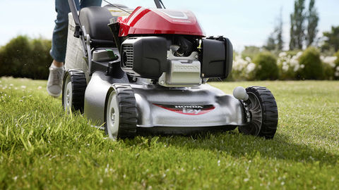 Person mowing the lawn with a Honda IZY mower
