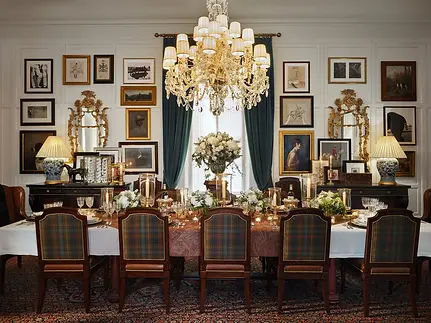 Elegant dining room with long table, chandelier, and framed art HOME
