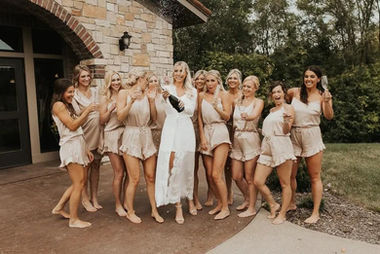 Bridal party popping champagne in front of Belle Âme Vineyard