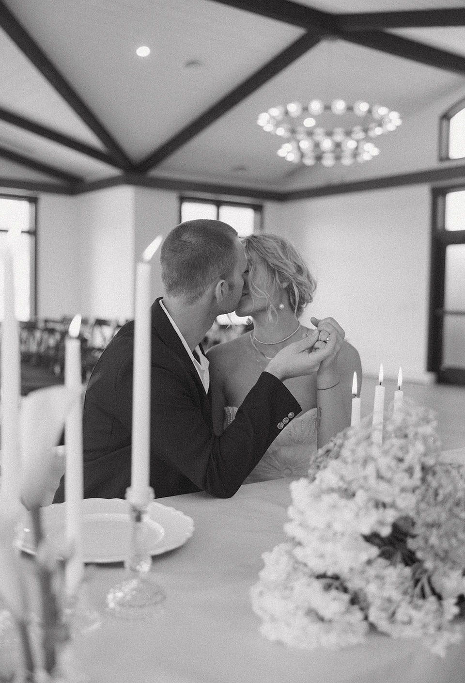 Romantic black-and-white moment of the couple kissing at their reception inside a modern Wisconsin v