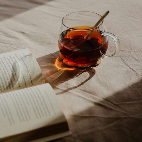 kop thee met boek op bed