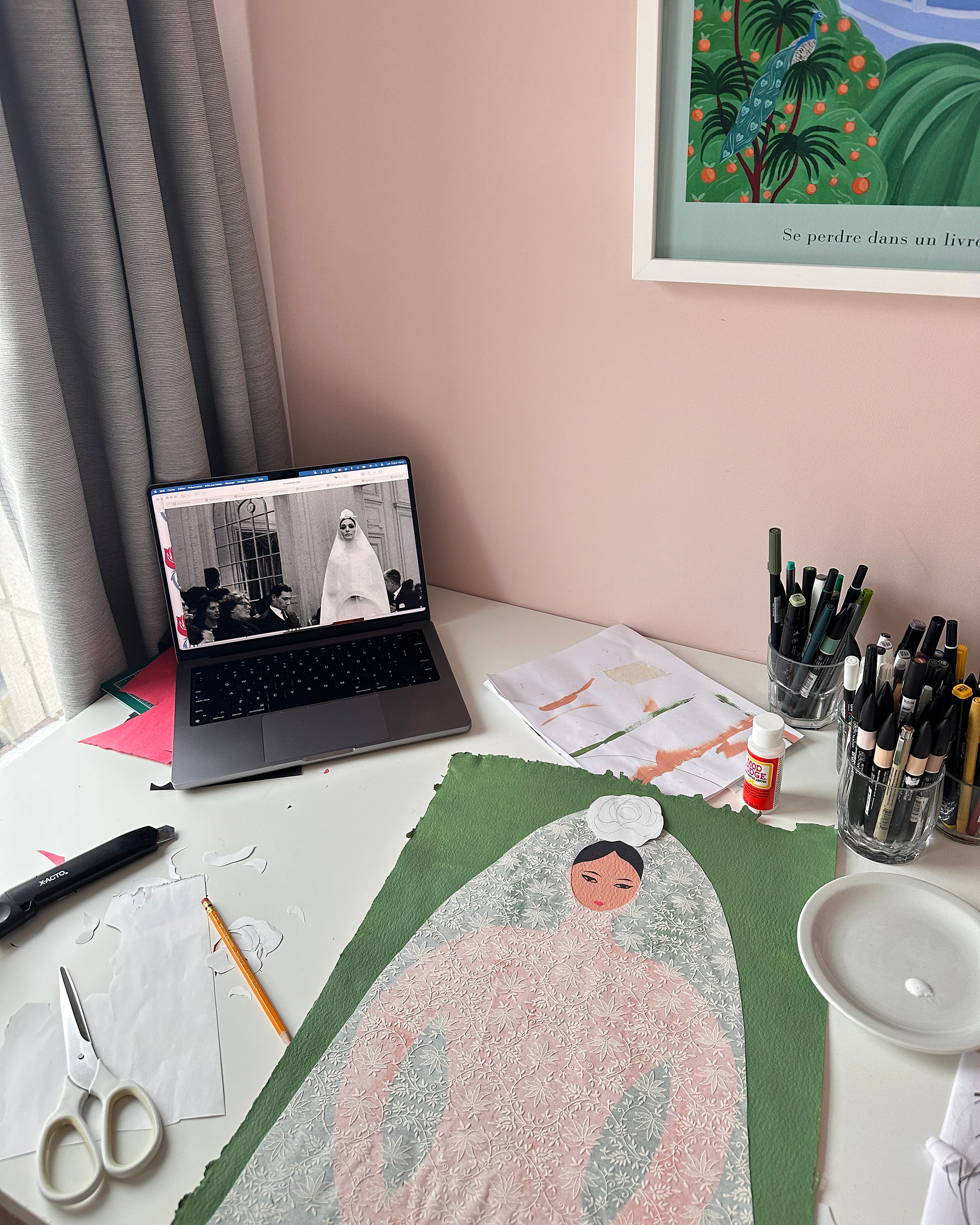 Illustration en collage en cours sur un bureau, avec dentelle en papier et matériel de dessin.
