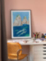 Framed Swimmers by the Rocks art print displayed in a home interior