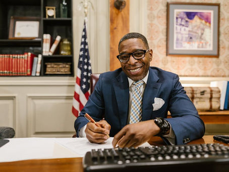 Man in office signing document smiling