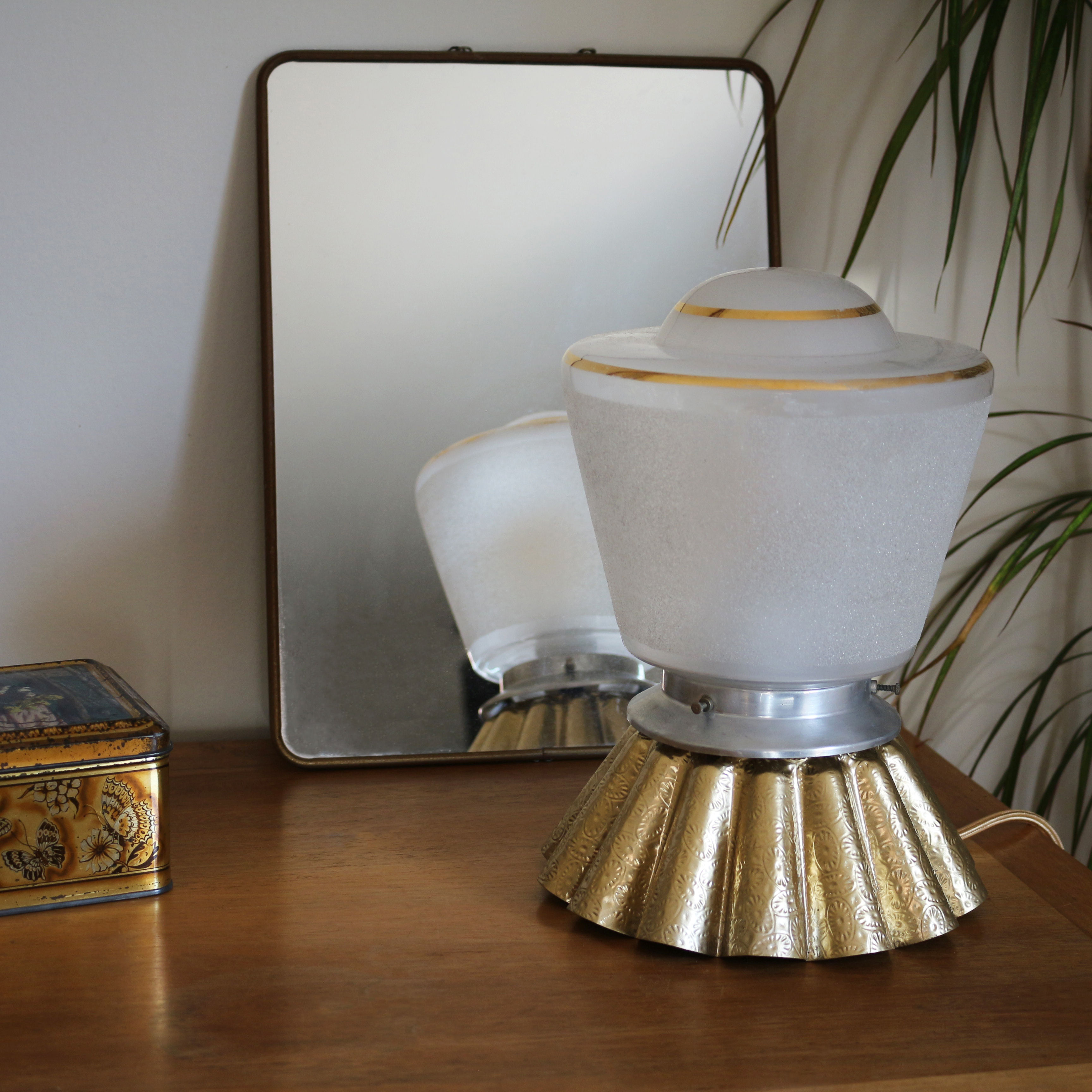 Lampe upcycling créée avec une applique globe sablée et comme base un moule à gâteaux doré.