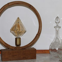 Lampe créée avec un cercle en bambou posé sur un socle en bois.