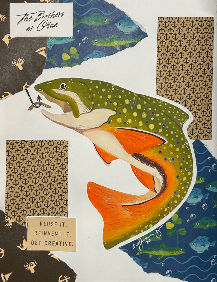 Green and orange trout surrounded by fishing themed scrap paper and packaging.