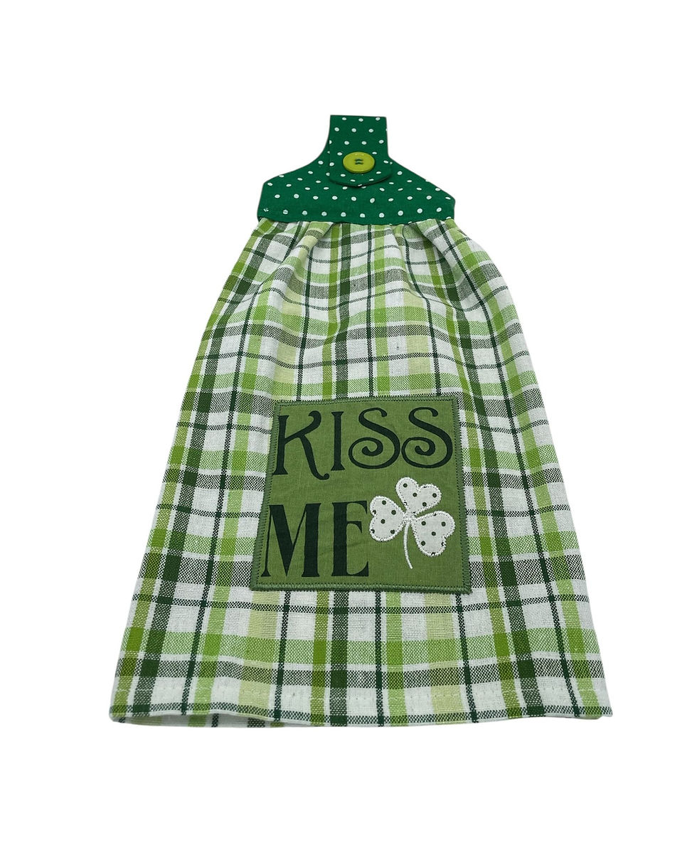 Green plaid hanging kitchen towel with 'KISS ME' and shamrock