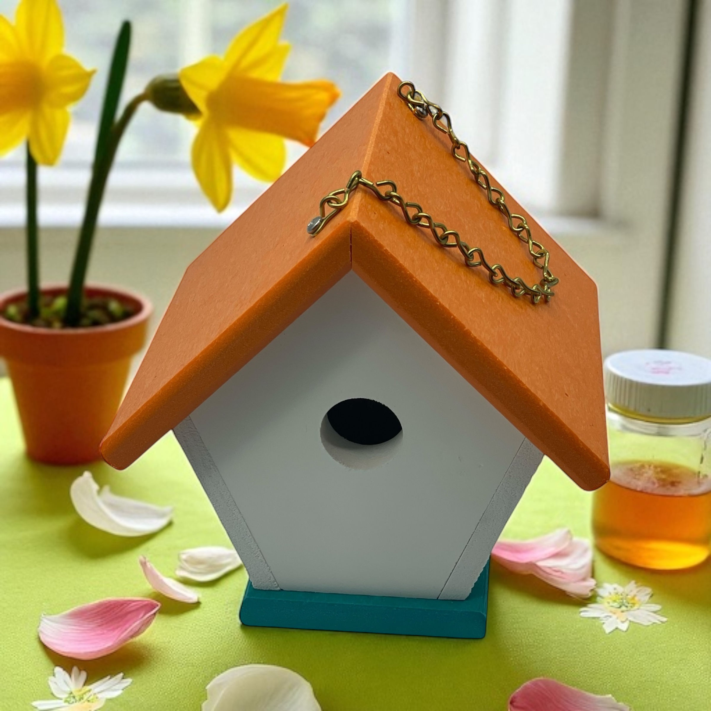 Orange and white birdhouse with honey