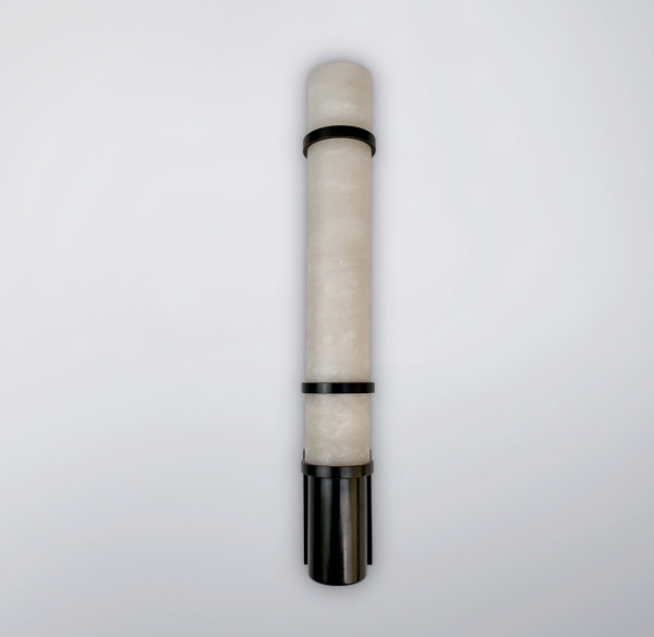 The Sandhurst, hand-carved organic alabaster tube shade with brass fittings and slim backplate, showcasing its translucent properties. Pictured in an ebonised finish.