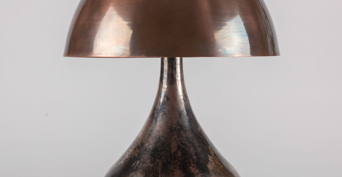 Potbelly table lamp in antique nickel with an aged ebony base and a hemispherical brass shade for diffused lighting.