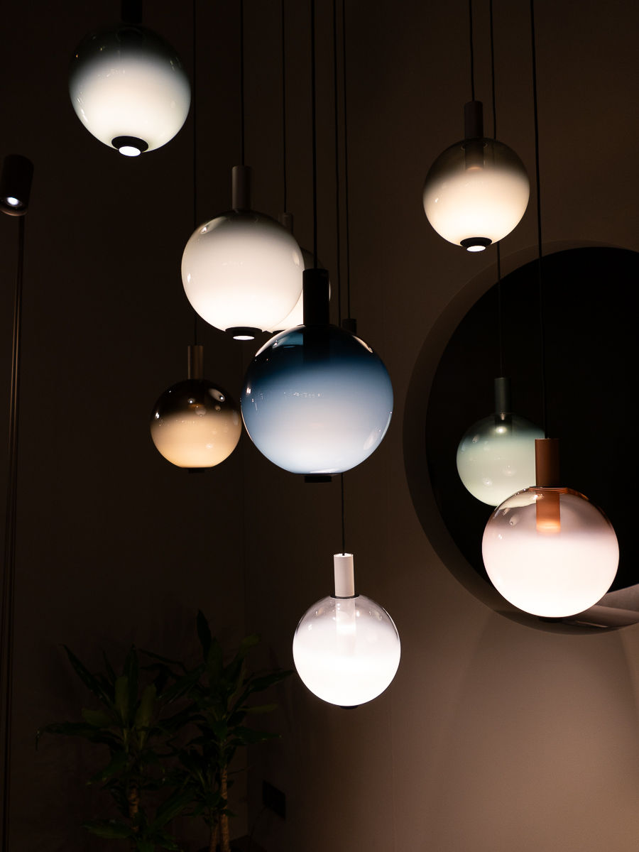 Farbige Glaspendelleuchten hängen im Raum