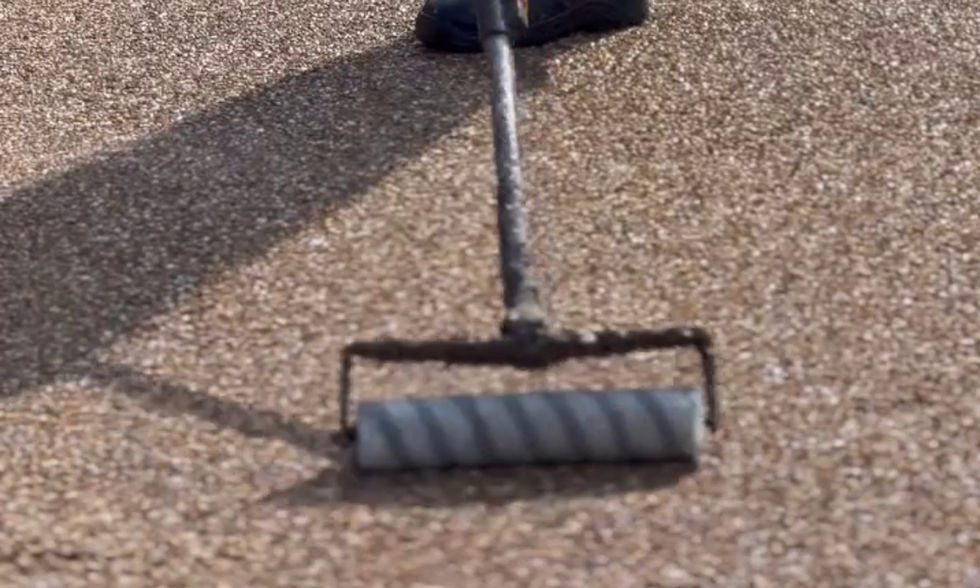 Worker applying resin sealant during rejuvenation of a residential driveway in Bristol by Bristol Resin Company