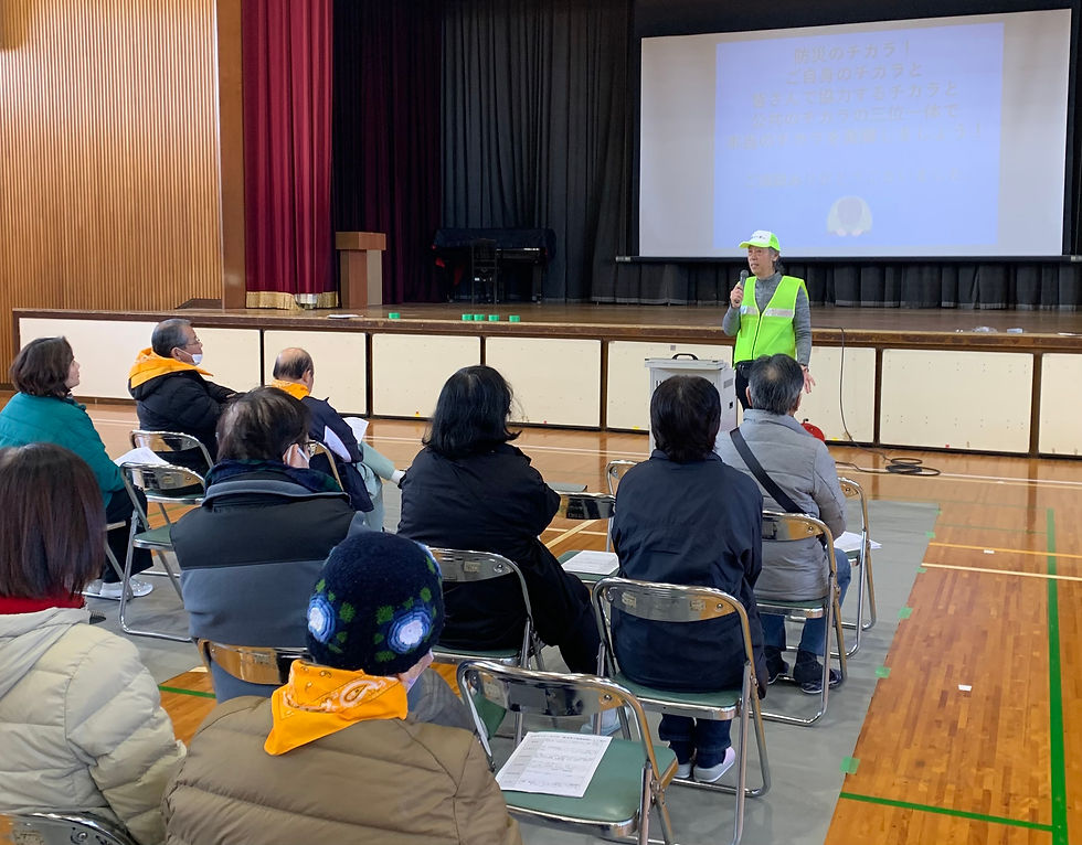 体育館に集まった防災訓練参加者の前で防災セミナーを講話