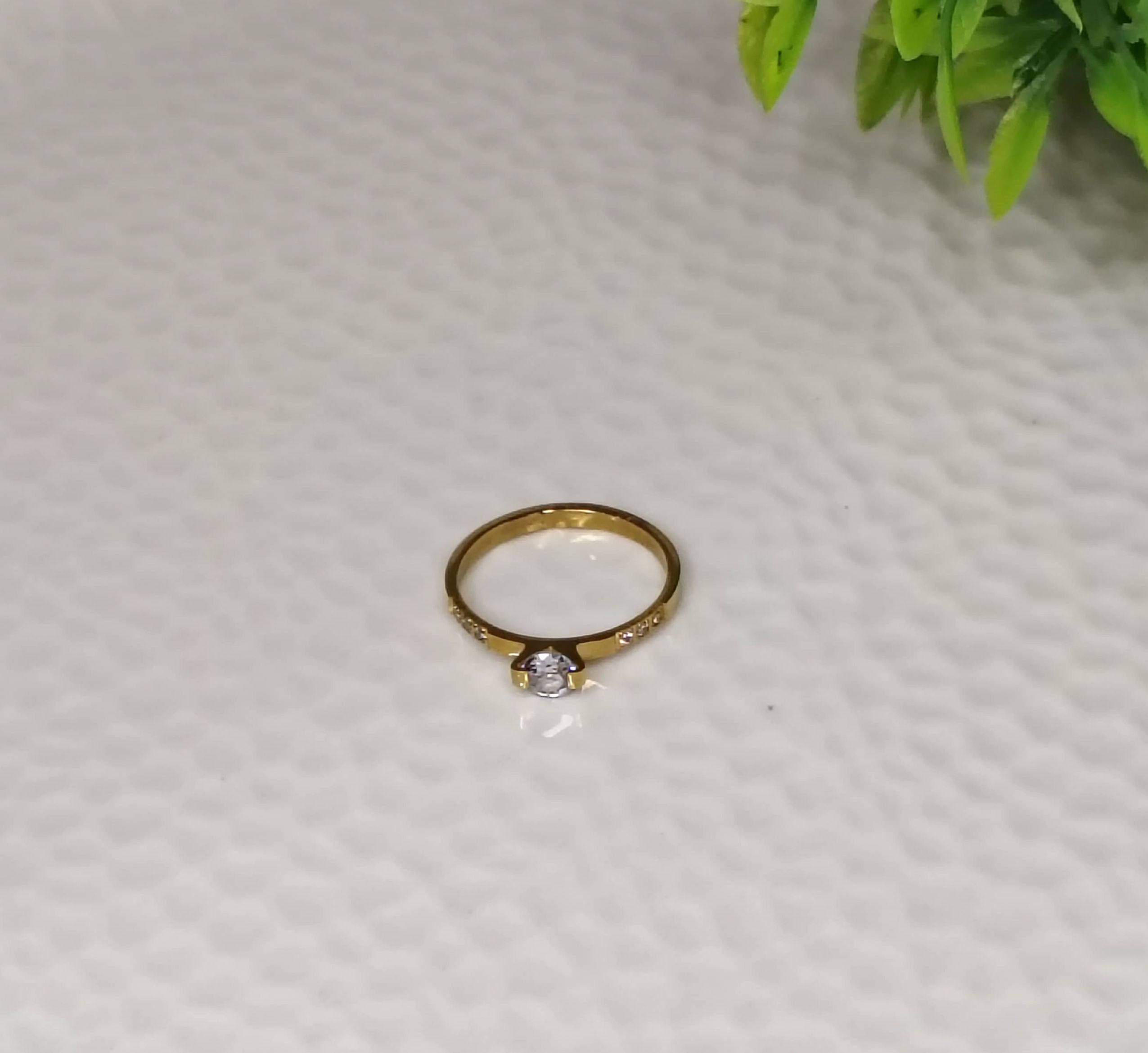 Gold small solitaire ring with a round diamond.