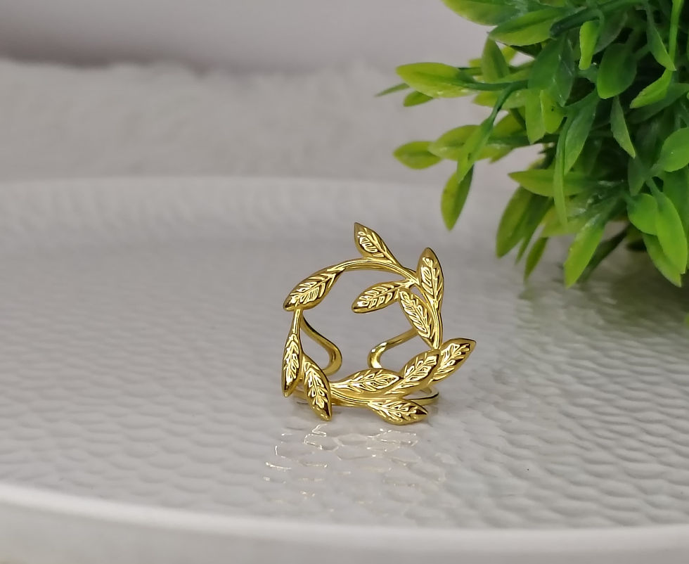 Gold leaves ring on a white textured surface.