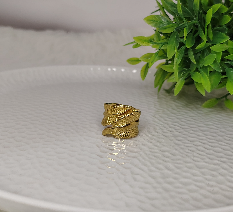 Gold leaf ring on a white textured plate with greenery