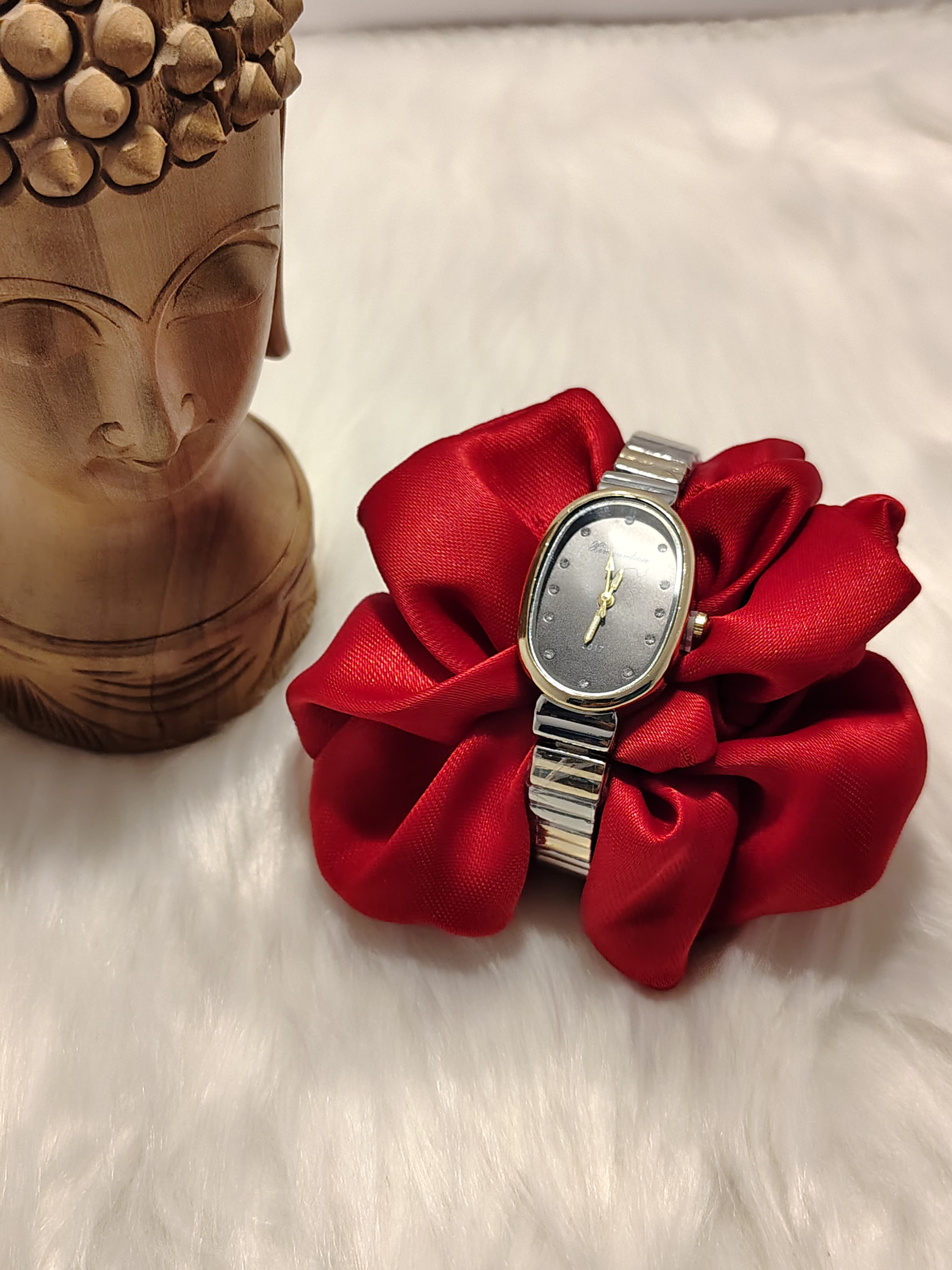 Dual tone strap watch on a red fabric flower petal
