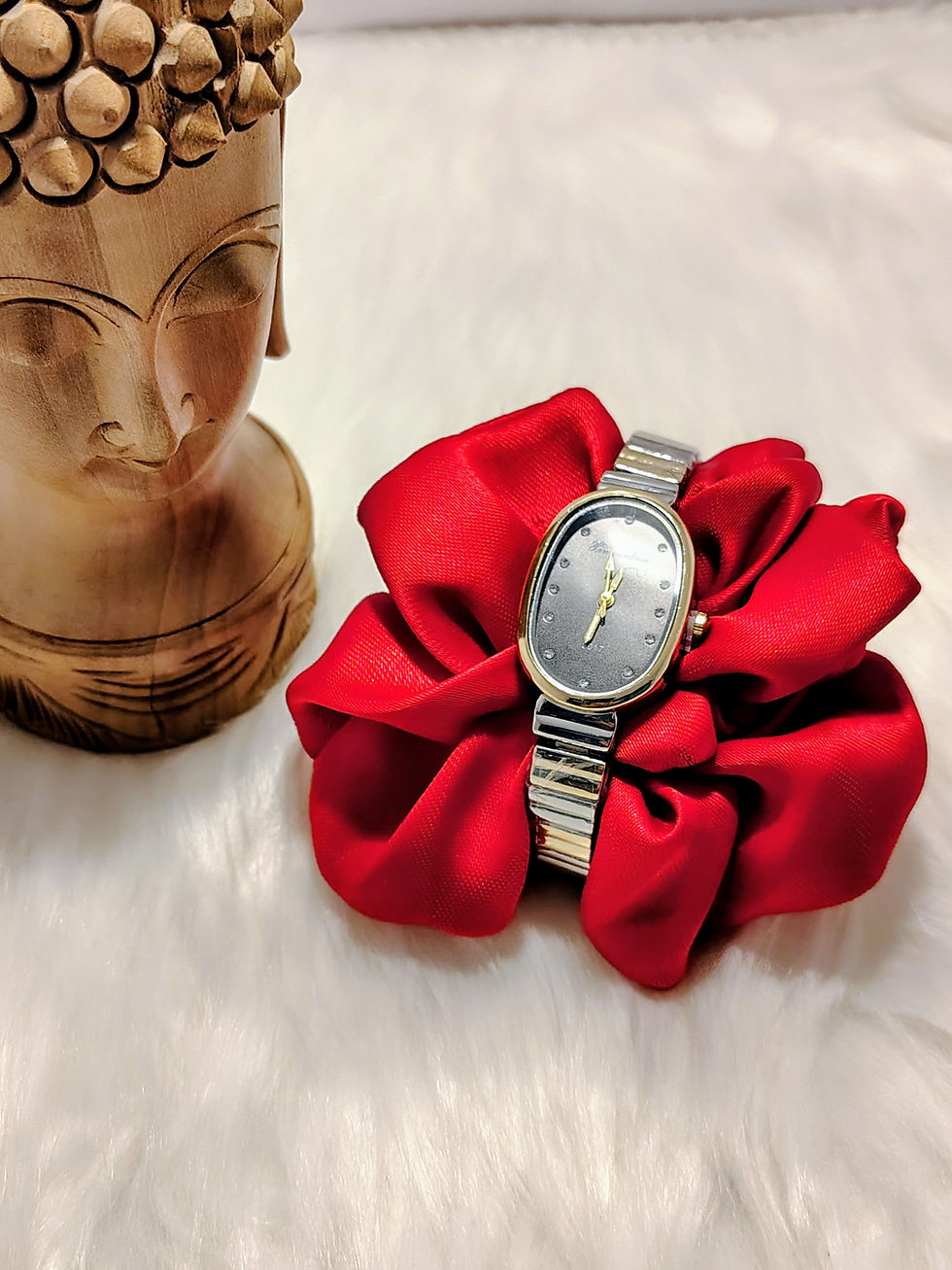 Dual tone strap watch on a red fabric flower.