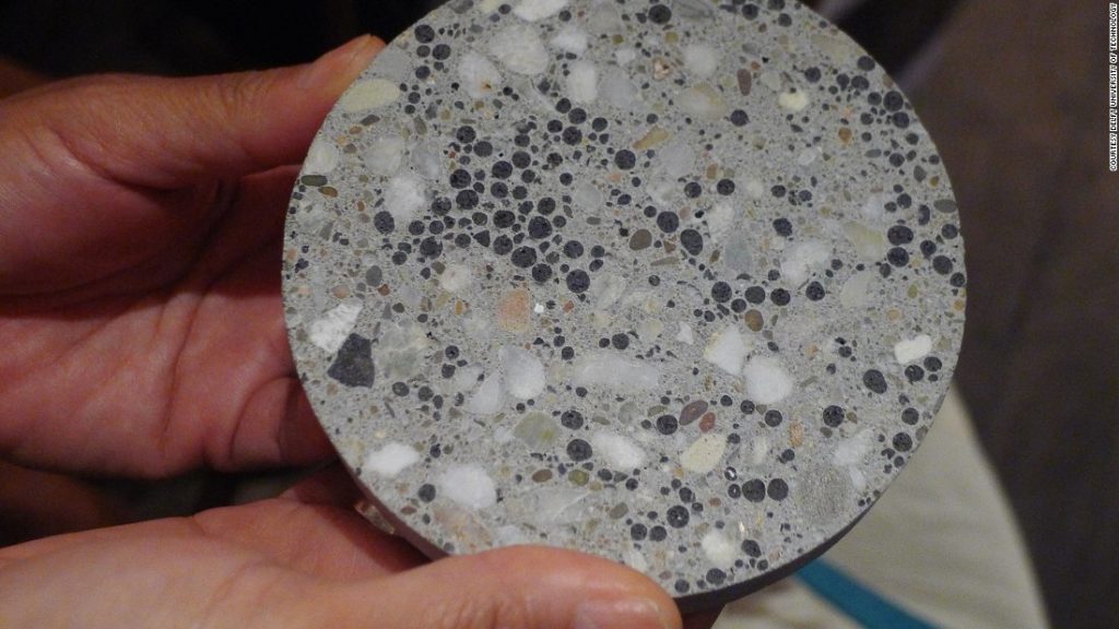 A circular piece of bioconcrete which is great with black and brown dots all of it