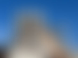 Stone pointed statues with a green ridge of stone behind them