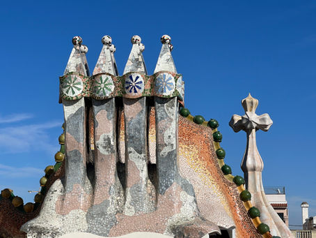 Stone pointed statues with a green ridge of stone behind them