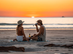 Having a beer on a beach at sunset
