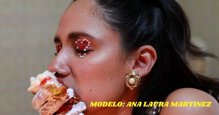 Un close up de una mujer dandole una mordida a una rebanada de pastel de su mano.