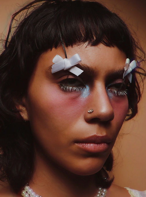 Fotografía close up de maquillaje y mujer con los ojos en blanco viendo hacia arriba. 