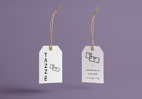 Mockup de unas etiquetas blancas colgantes para ropa con el logo de Tazzé