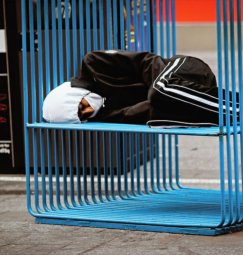 man in black jacket sitting on blue benc