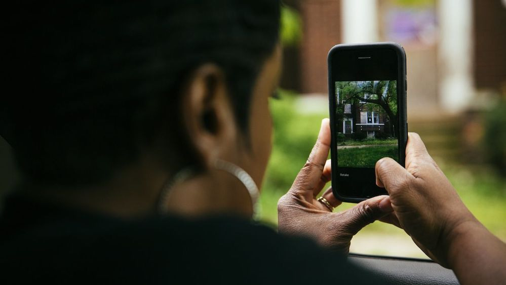 Tyra Johnson-Morris takes a photo of a property in Chicago using DealMachine, a real-estate investment app that uses GPS to identify property owners.