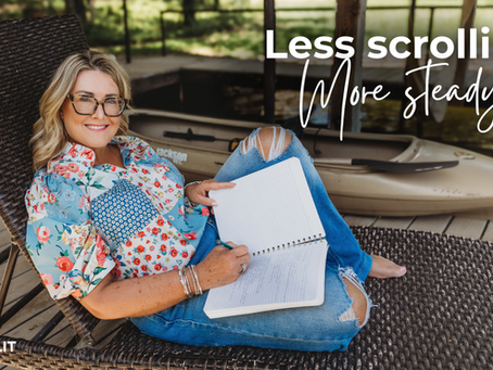 Michelle sitting outside on a patio chair writing in her journal. She's wearing blue jeans and a flowered shirt, looking at the camera and smiling.